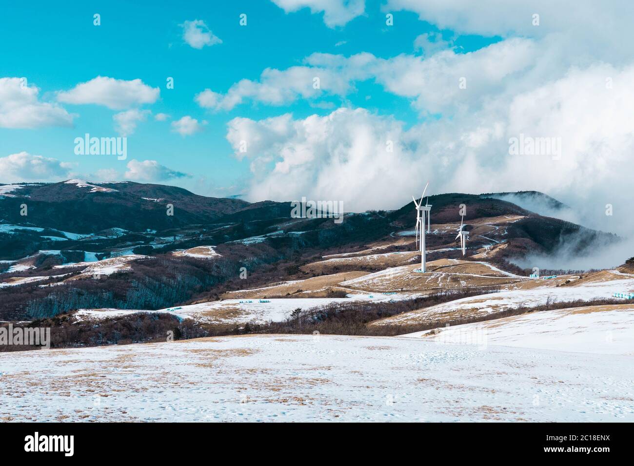 Sommet de la montagne avec des pales de turbine électrique vue sur une colline enneigée. Banque D'Images