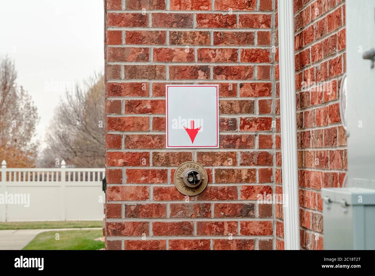 Mur en brique avec flèche pointant vers l'extincteur automatique à incendie Banque D'Images