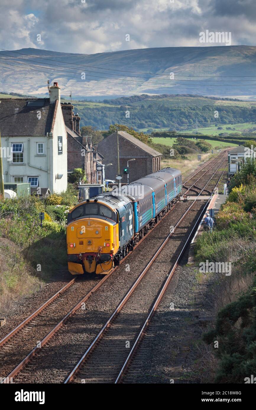 Services ferroviaires directs classe 37 locomotive 37401 arrivant à la gare de Drigg sur la ligne de chemin de fer rurale de la côte de Cumbrian avec un train ferroviaire du Nord Banque D'Images