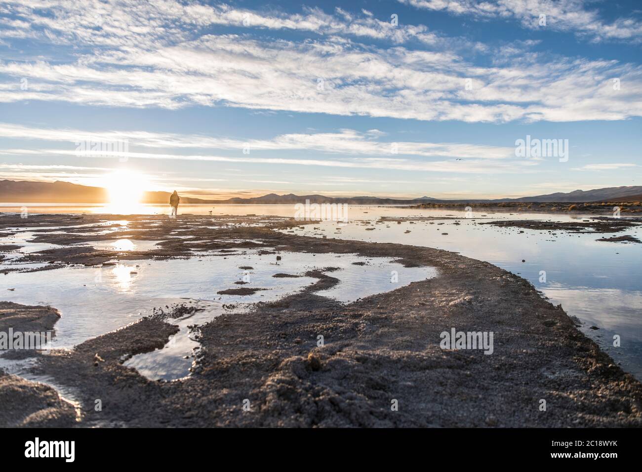 beau paysage dans un lac gelé avec un ciel bleu et le soleil se levant à l'horizon Banque D'Images