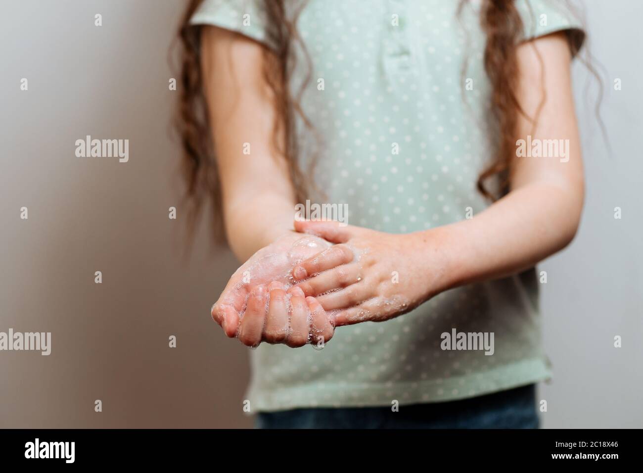 Mains d'enfants dans de la mousse savonneuse. N'oubliez pas de se laver les mains. Prévention Banque D'Images