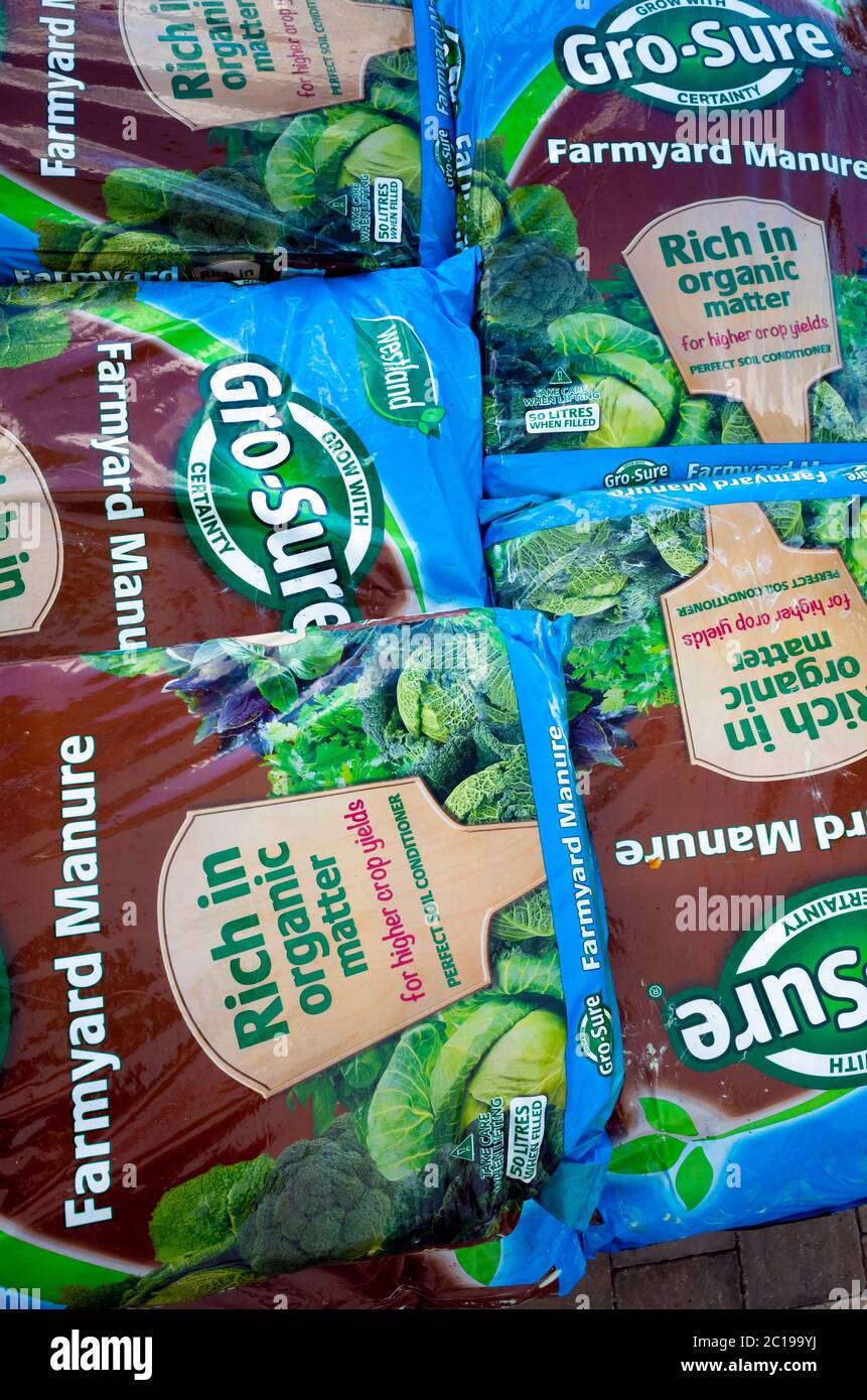 Une pile de sacs de fumier de ferme l'amélioration de la qualité des sols et la promotion de la croissance des plantes en vente dans un centre de jardinage Banque D'Images