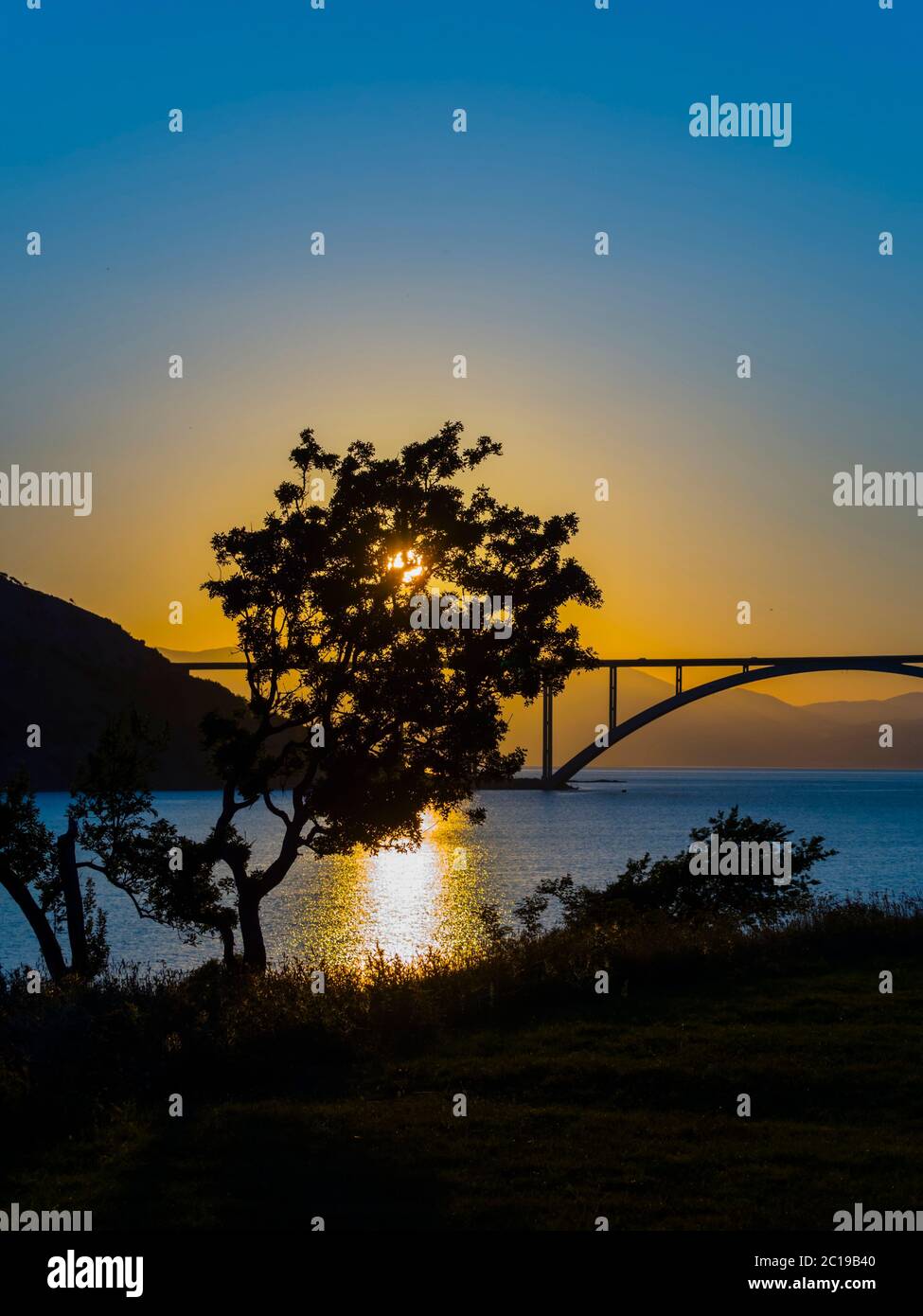Coucher de soleil pont paysage continent à l'île Krk Croatie voir la vue à travers l'arbre dominant Banque D'Images