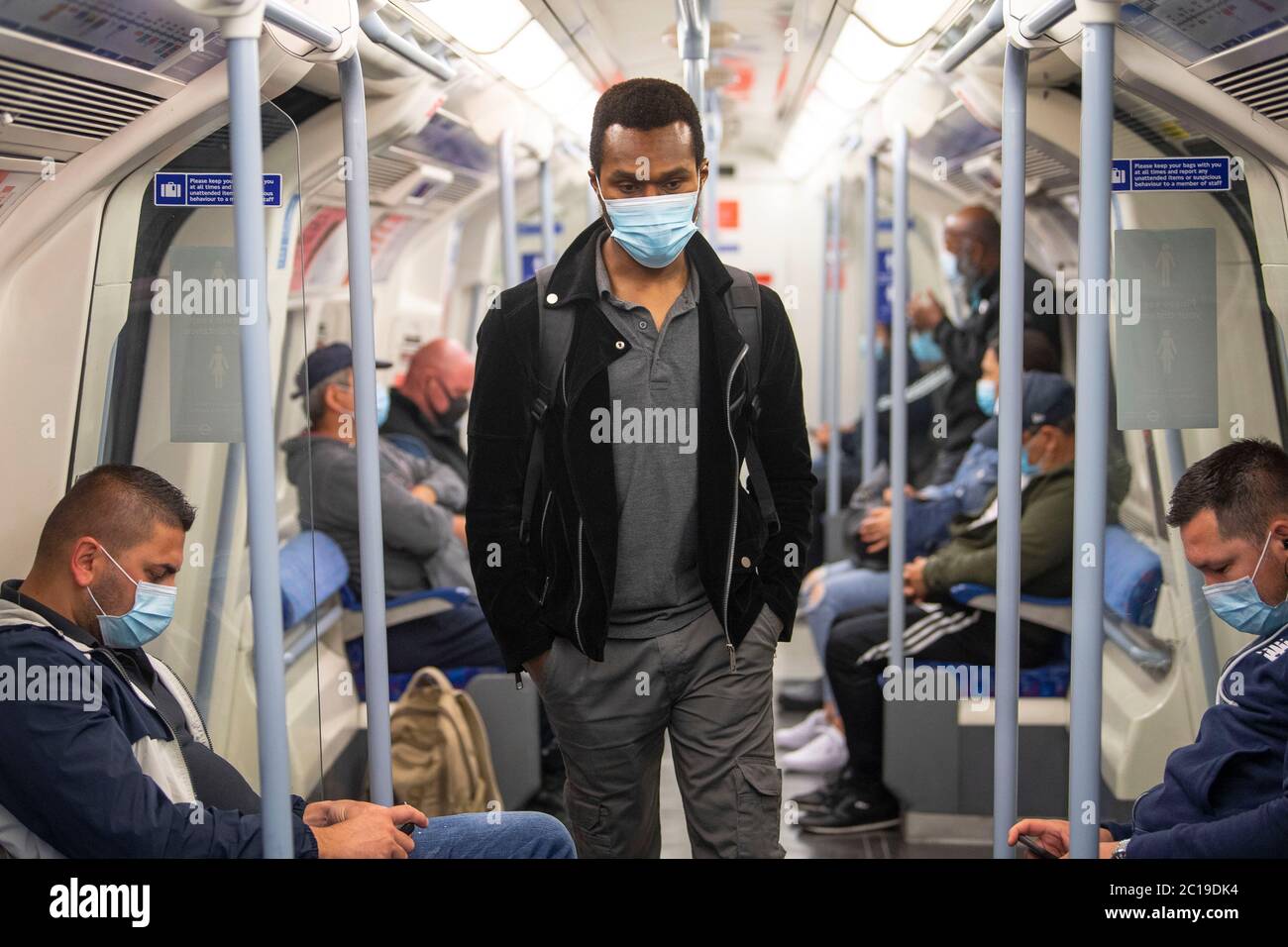 Les passagers portant des masques sur la ligne Jubilee de Londres est alors que les couvertures de visage deviennent obligatoires dans les transports publics en Angleterre avec l'assouplissement de nouvelles restrictions de verrouillage pendant la pandémie du coronavirus. Banque D'Images