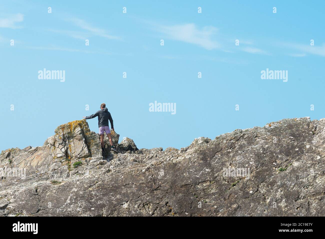 Un homme debout sur des rochers. Banque D'Images