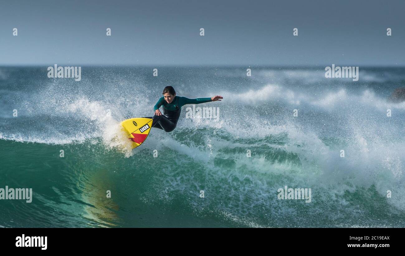 Une image panoramique d'un jeune adolescent en action de surf à Fistral à Newquay, en Cornouailles. Banque D'Images