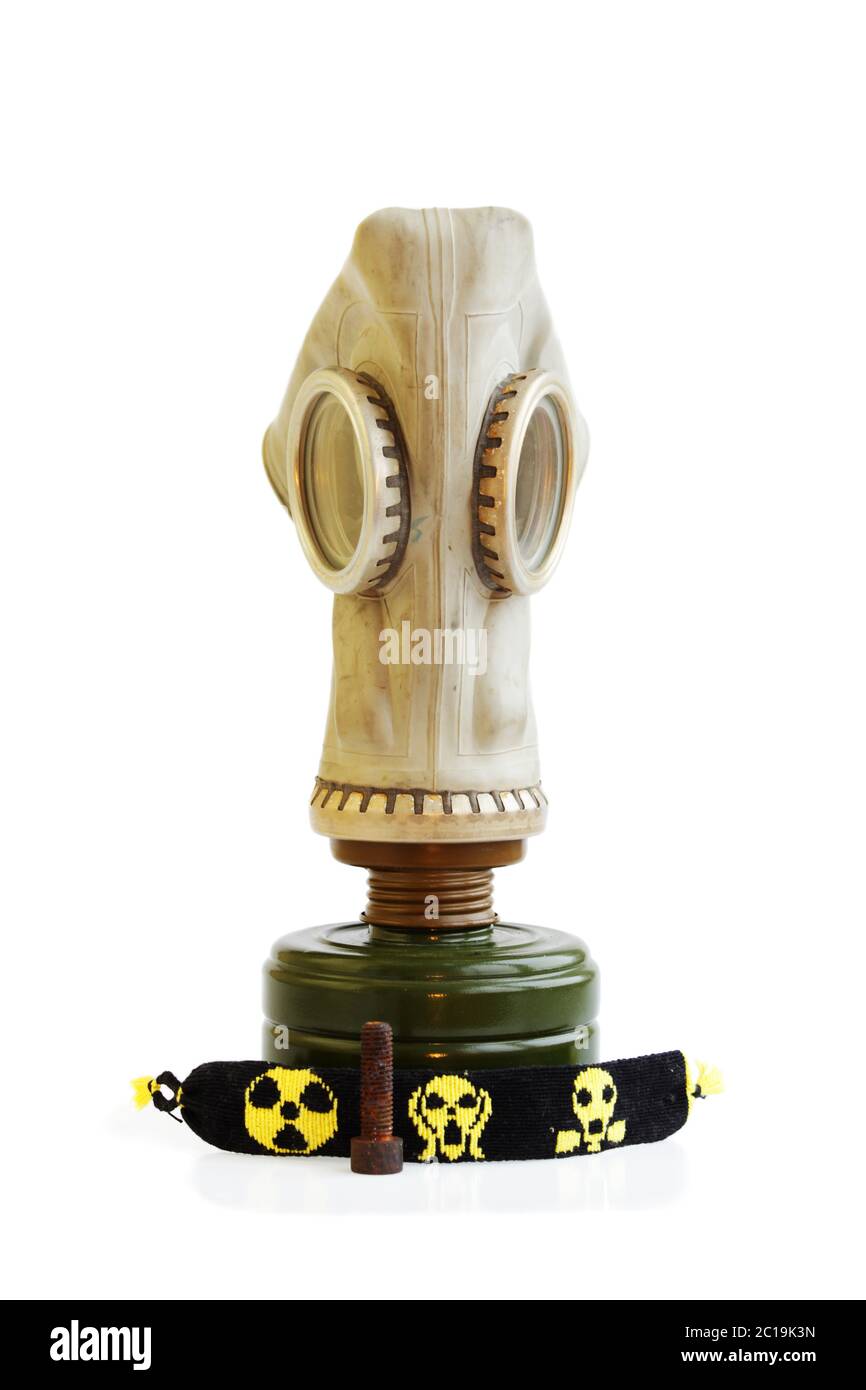 Trophées du pédonteur : vieux masque à gaz russe, clou rouillé et boules jaunes-noires sur fond blanc. Banque D'Images
