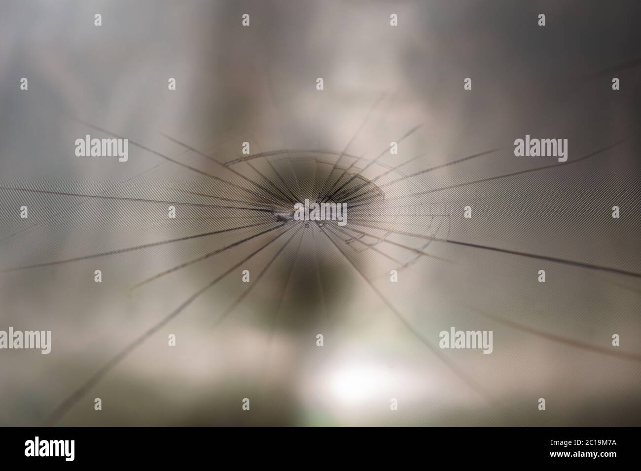 arrière-plan abstrait de l'écran lcd tft cassé avec fissures radiales localisées d'un seul coup : gros plan avec mise au point sélective et flou Banque D'Images