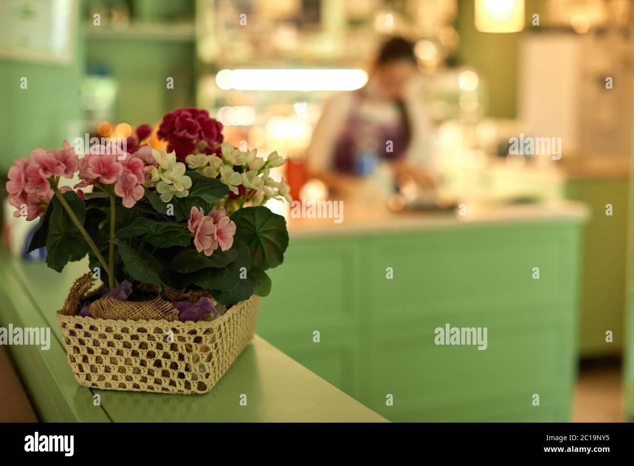 panier avec fleurs et blur femme travaillant dans la confiserie. sucrée magasin Banque D'Images