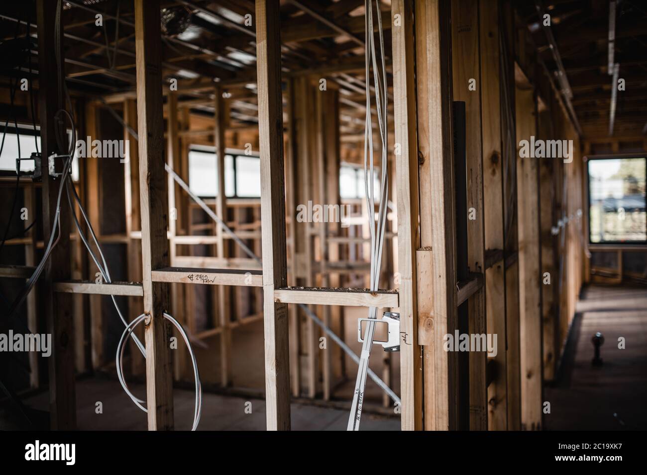 Ensemble de construction d'une maison en cours de construction avec des fils exposés et des poutres en bois Banque D'Images