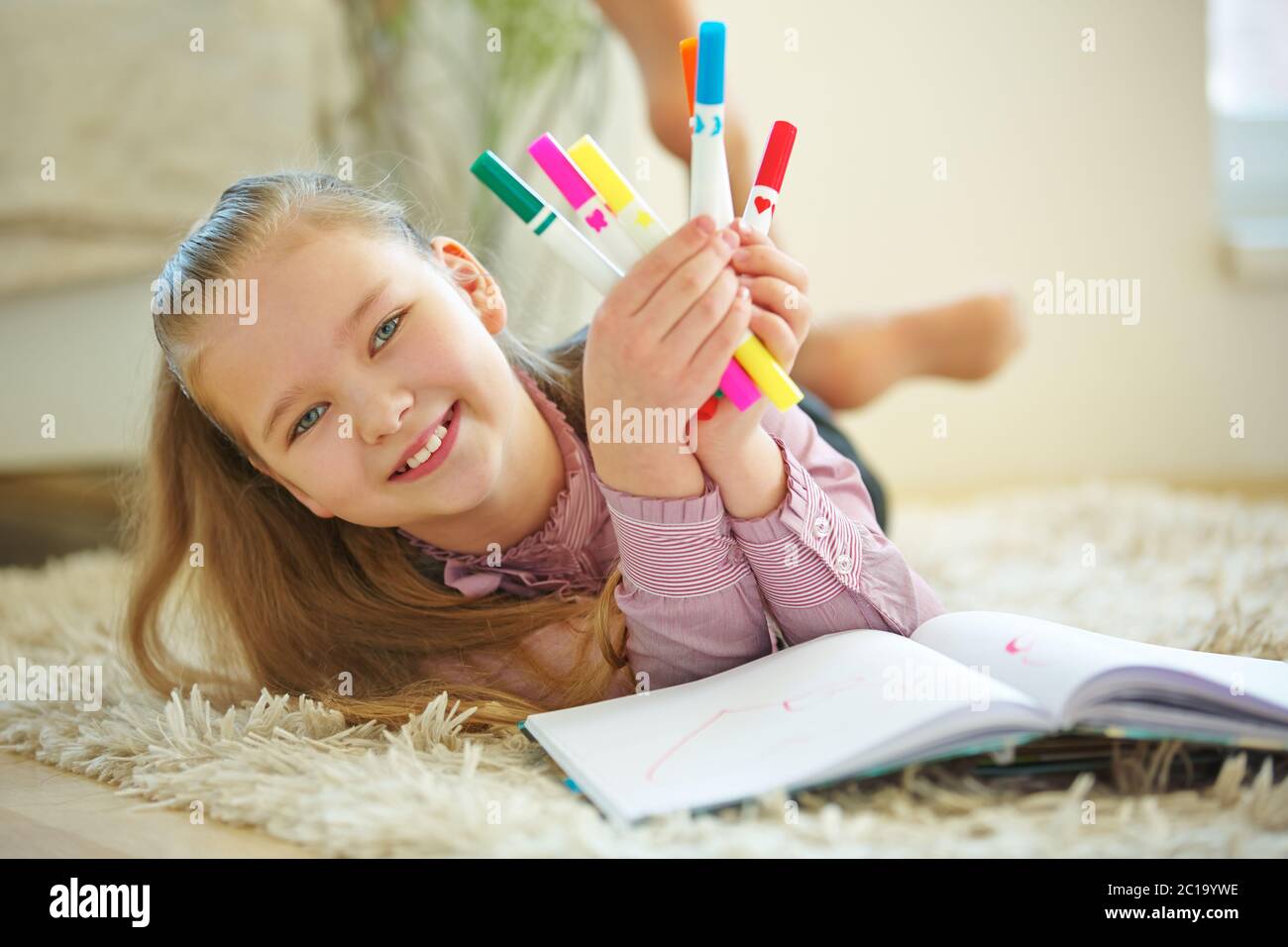 Enfant souriant avec beaucoup de crayons colorés pour la peinture Banque D'Images