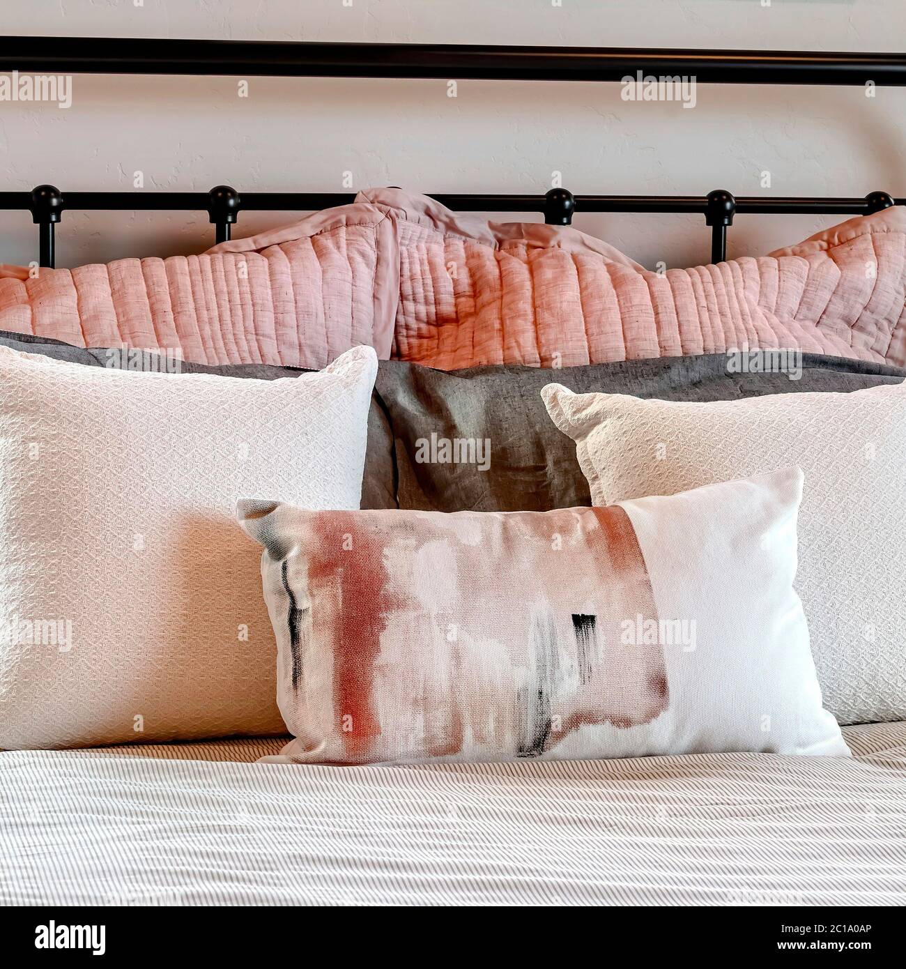 Lit simple à cadre carré avec oreillers moelleux sur tête de lit en métal  noir dans la chambre Photo Stock - Alamy