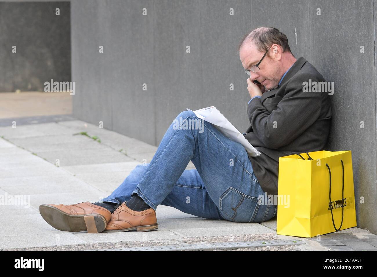 Birmingham, West Midlands, 15 juin 2020. Un homme prend un repos après avoir magasiné à Selfridges à Birmingham aujourd’hui alors que des milliers d’acheteurs frappent Birmingham pour acheter des articles qu’ils ont manqués depuis que les points de vente ont été fermés pendant le confinement de COVID-19. Beaucoup étaient des scènes tenant des paquets de sacs après une virée shopping. Deux hommes ont été vus marcher le long de New Street à Birmingham avec six sacs Selfridges. Crédit : arrêtez Press Media/Alamy Live News Banque D'Images