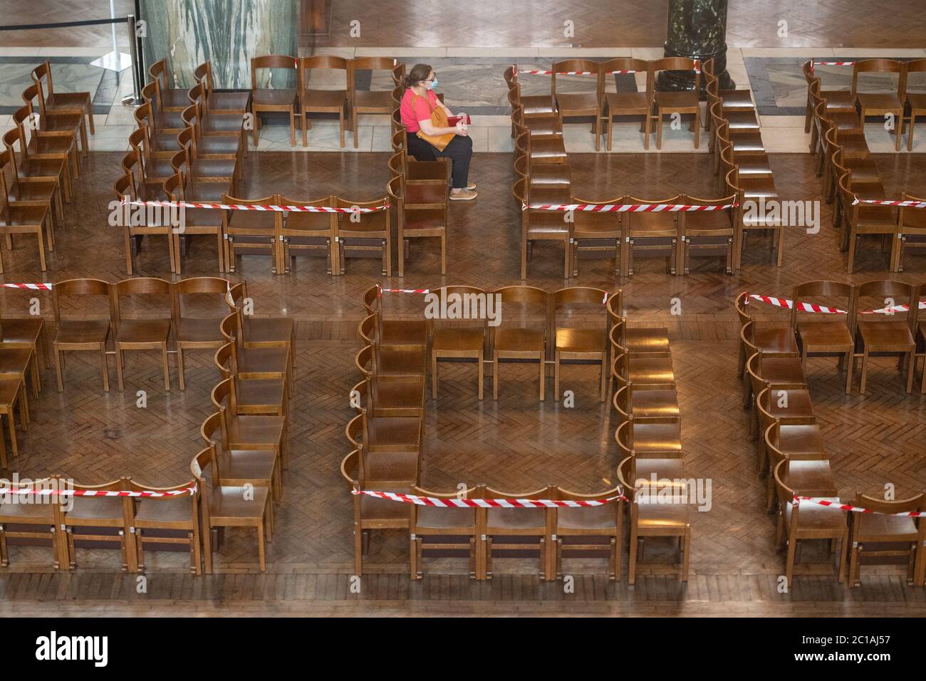 Une femme s'assoit sur des sièges disposés pour prendre des distances sociales à la cathédrale de Westminster, Londres, alors qu'elle accueille les gens de retour pour la prière individuelle avec l'assouplissement des restrictions de verrouillage du coronavirus en Angleterre. Banque D'Images