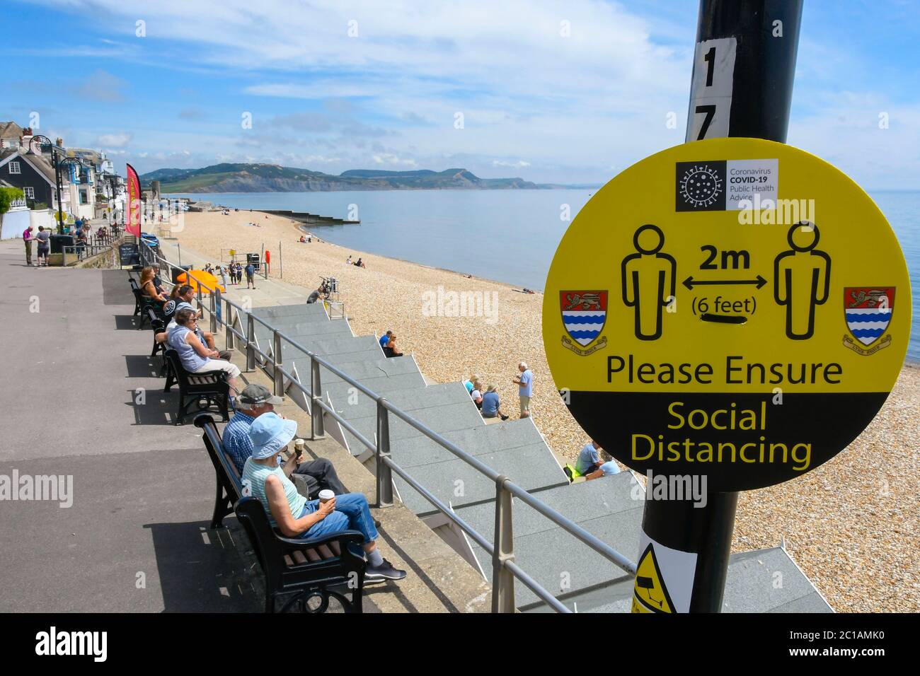 Lyme Regis, Dorset, Royaume-Uni. 15 juin 2020. Météo Royaume-Uni. Signe de distance sociale sur le front de mer que les visiteurs apprécient le soleil chaud à la station balnéaire de Lyme Regis à Dorset. Crédit photo : Graham Hunt/Alay Live News Banque D'Images