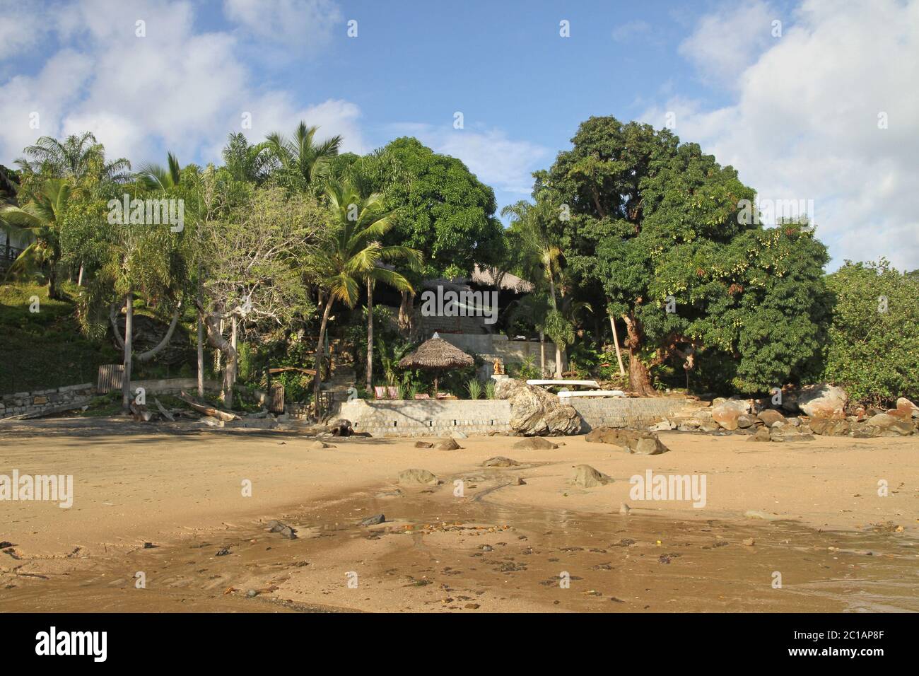 Vue sur les lapa et les arbres au toit de feuilles de palmier sur 293 sur Komba Guest House depuis la plage, le village d'Ampangorinana, l'île de Nosy Komba, Madagascar. Banque D'Images