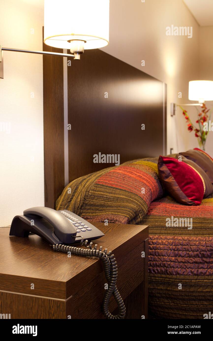 Téléphone et lit dans une chambre d'hôtel. Banque D'Images