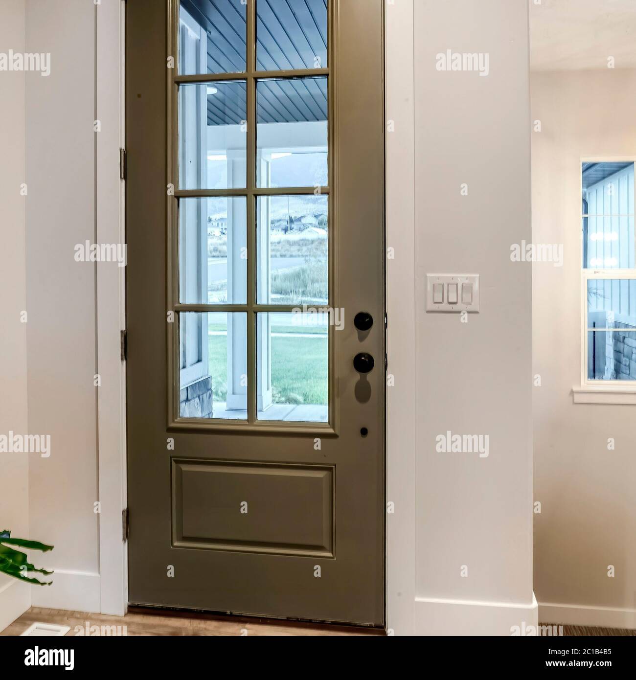 Porte avant à charnières carrées avec vitre, vue de l'intérieur de la  maison avec plancher en bois Photo Stock - Alamy