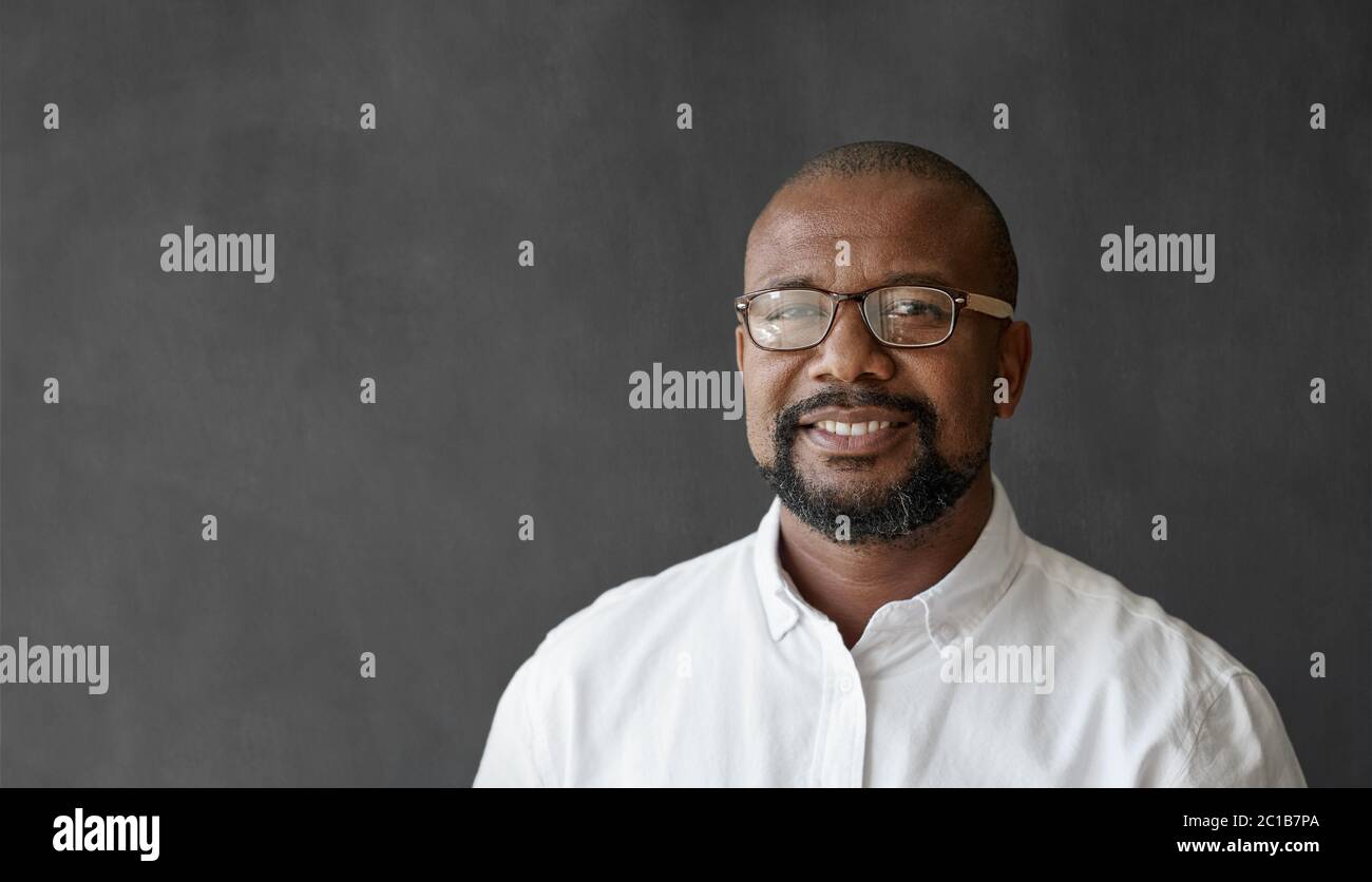 Homme d'affaires souriant et mûr à lunettes debout près d'un tableau blanc Banque D'Images
