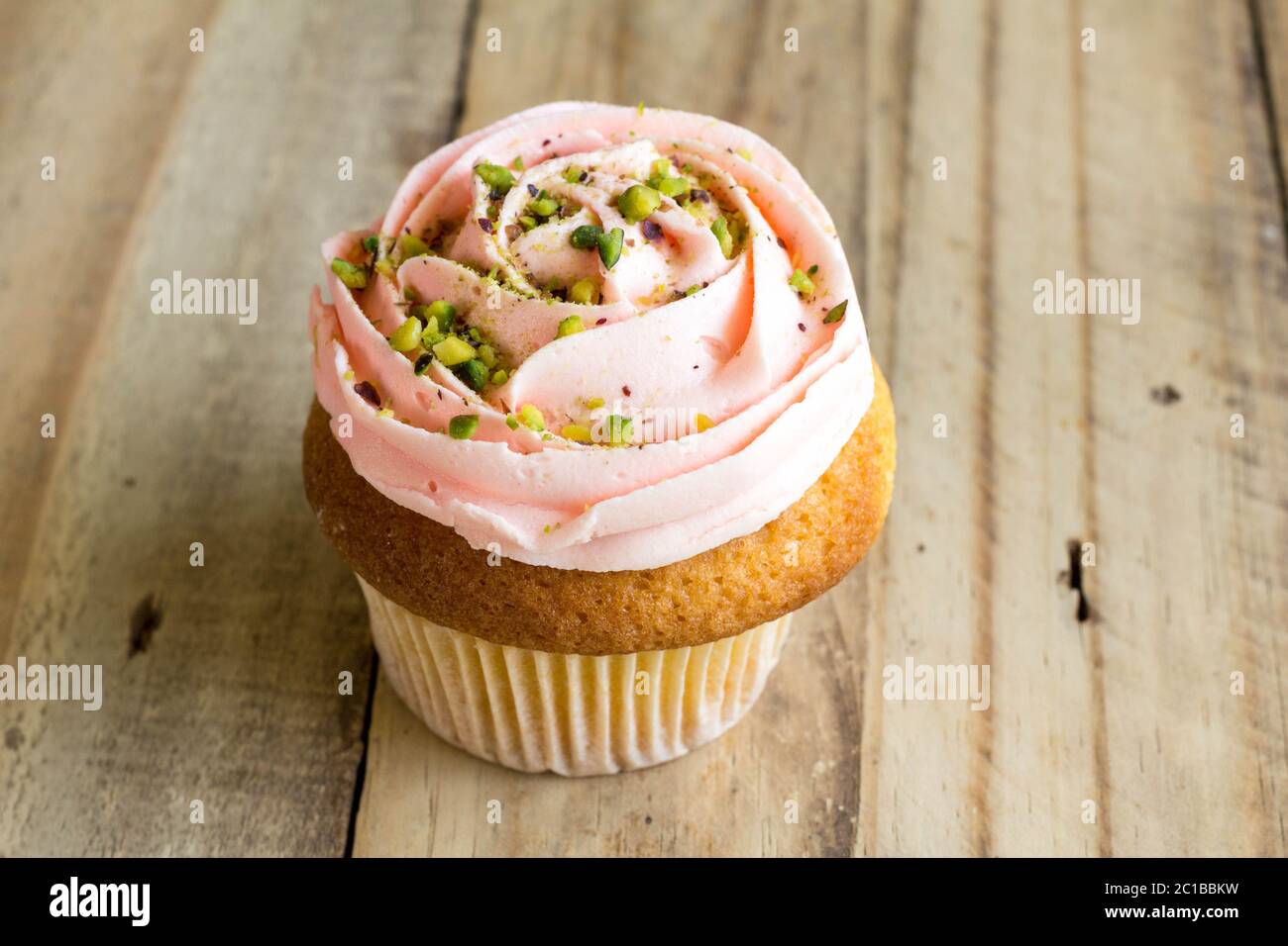 Cup Cake rose sur table en bois rustique, Close up Banque D'Images