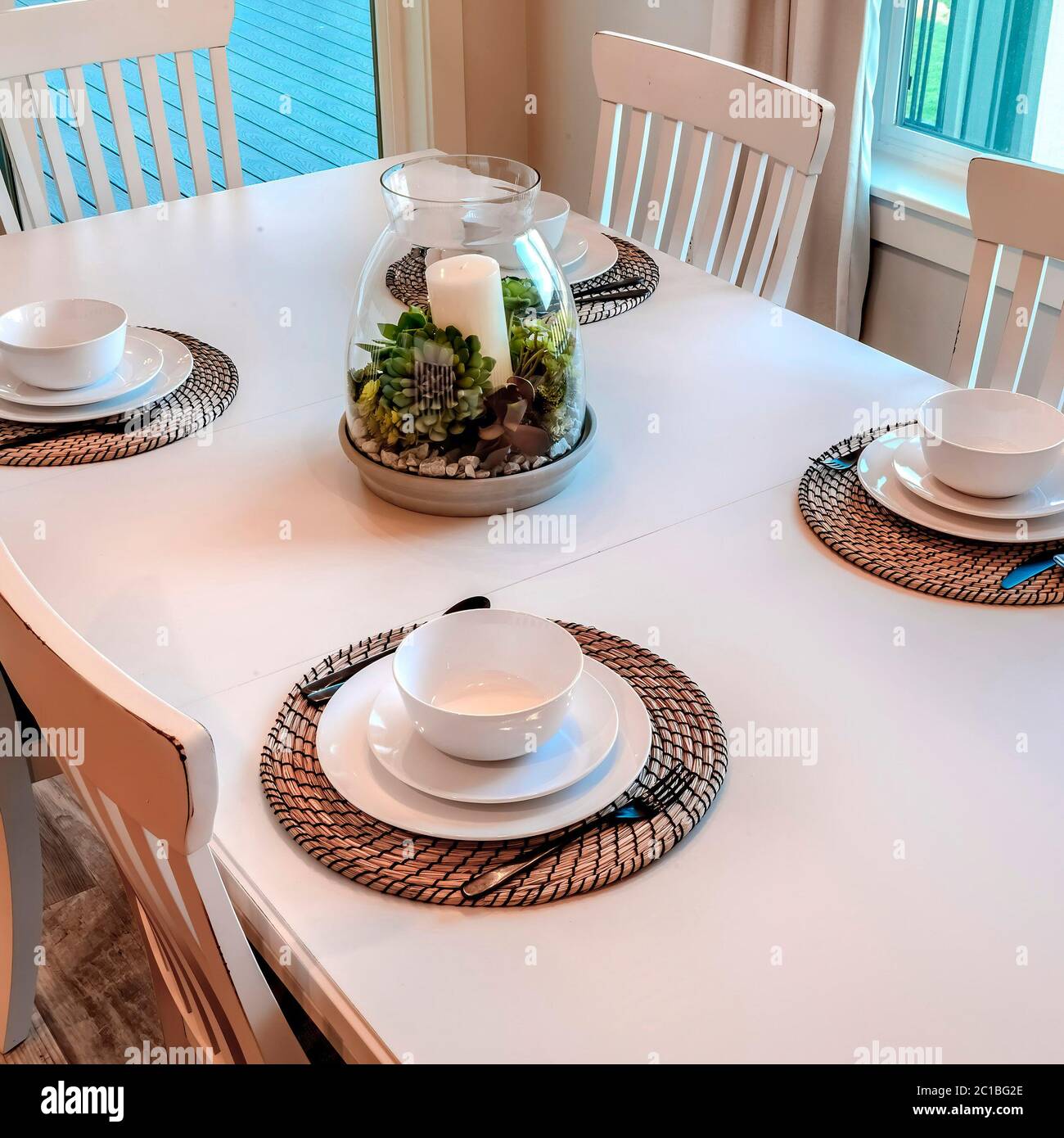 Cadre carré table de dîner avec vaisselle sur les sets de table disposés  autour d'une pièce maîtresse Photo Stock - Alamy