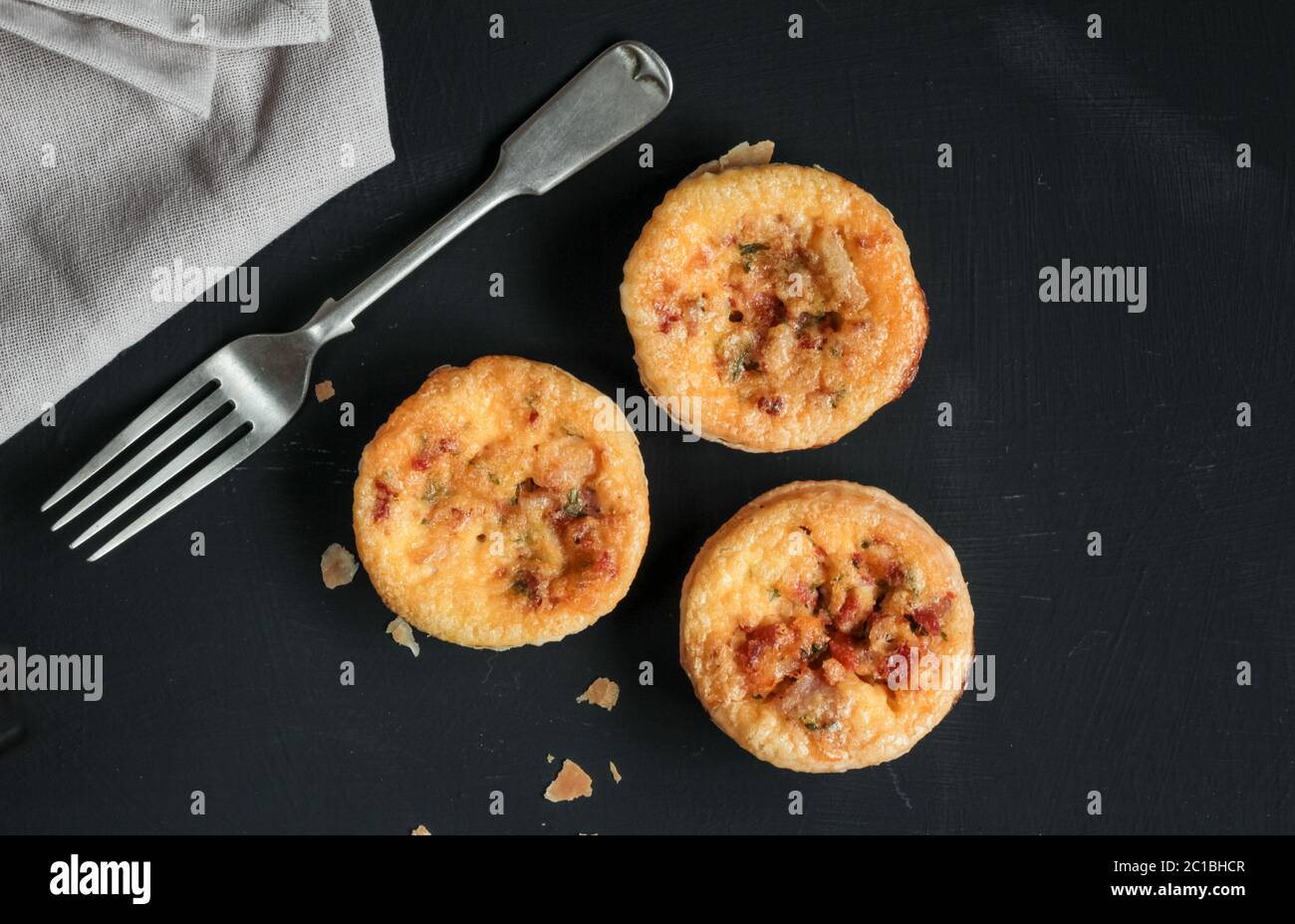 Mini quiches salés sur tableau noir avec une fourchette Banque D'Images