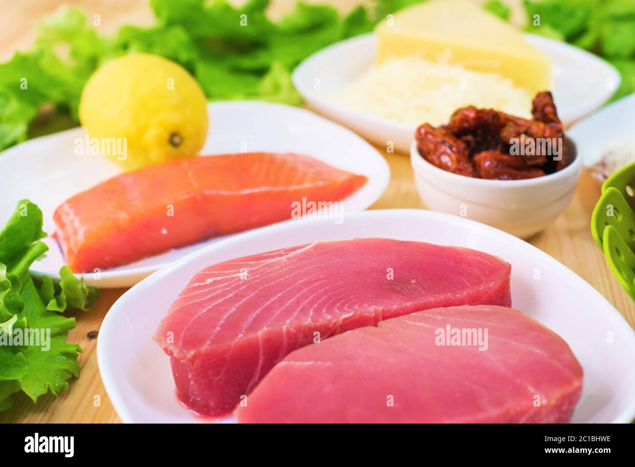 Filet de thon cru sur une table avec une cour de salade grecque avec des concombres et des tomates de saumon et de citron ainsi que du chee Banque D'Images