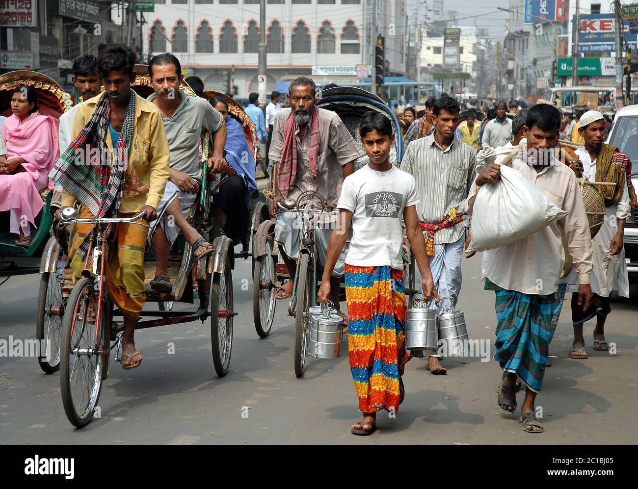 Une foule de personnes marchant ou parcourant des pousse-pousse le long de la rue à Dhaka, au Bangladesh. C'est une scène typique de la vie locale à Dhaka, la capitale. Banque D'Images