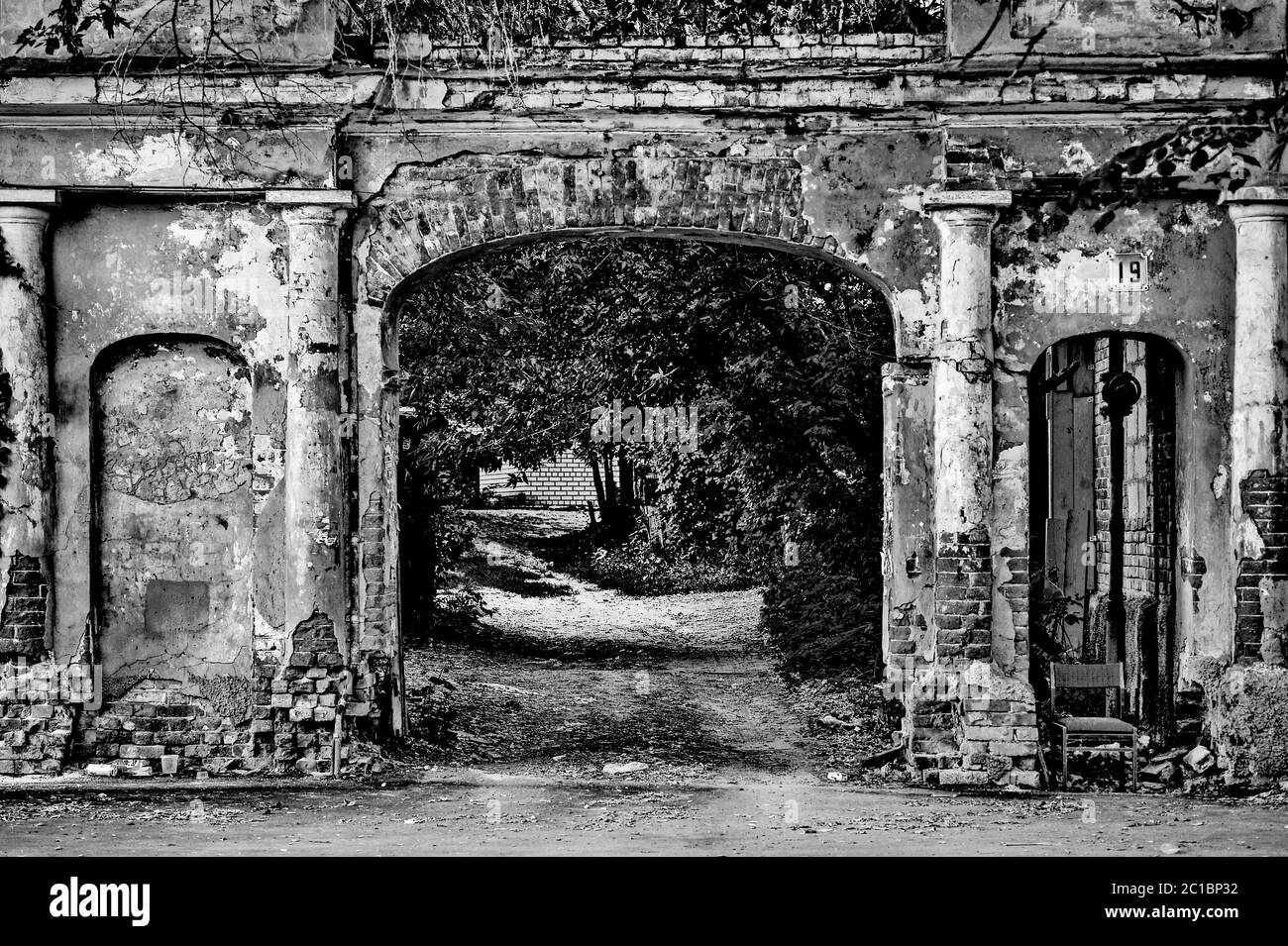 Pittoresque vieille brique brisée arch dans le cour de la ville Banque D'Images