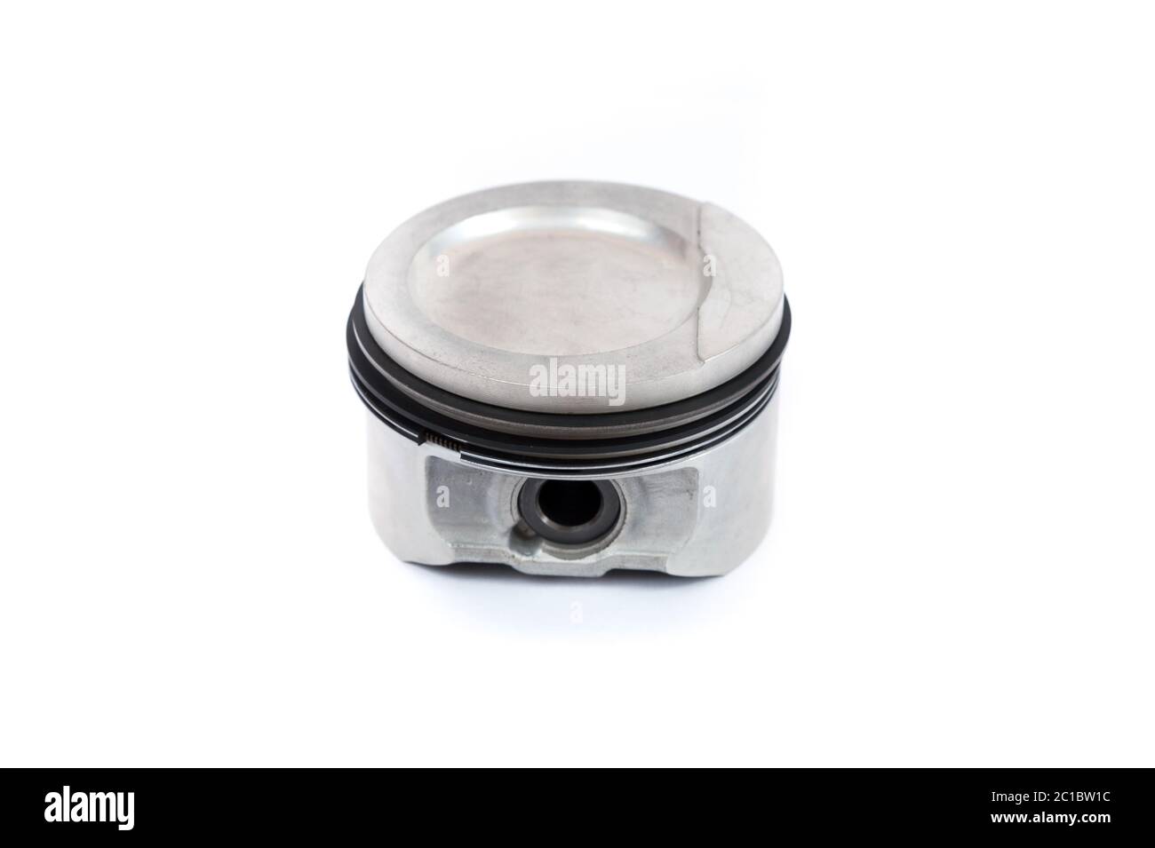 Un piston de gros plan d'un moteur à combustion interne avec des segments de piston isolés sur un fond blanc. Nouvelles pièces de rechange pour le moteur Banque D'Images