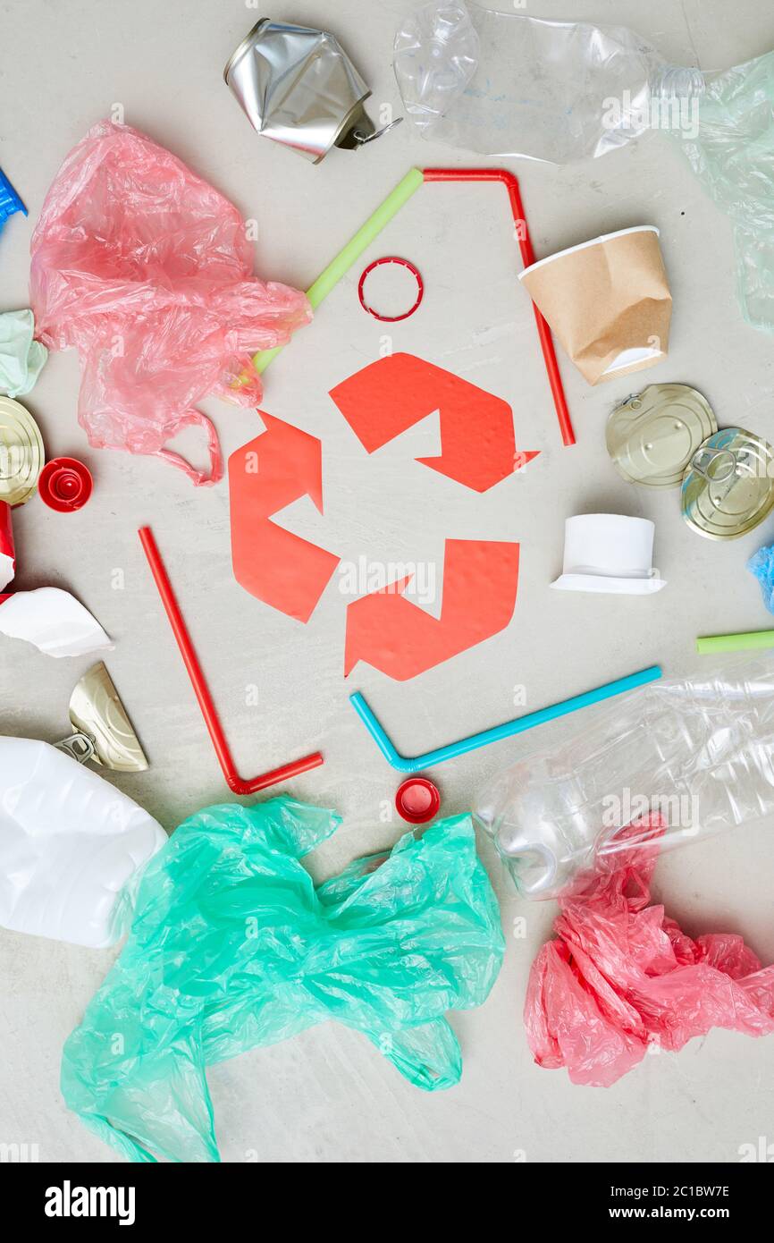 Vue en grand angle des emballages bouteilles et canettes autour du symbole de recyclage rouge Banque D'Images