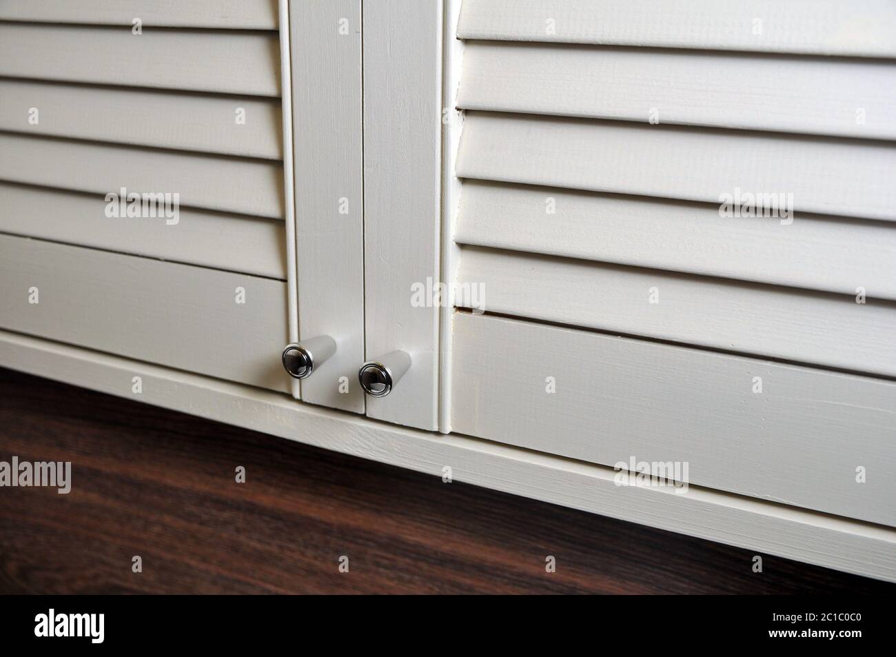 placard avec portes-persiennes pour la salle de bains, toilettes avec poignées en acier inoxydable, gros plan. Banque D'Images