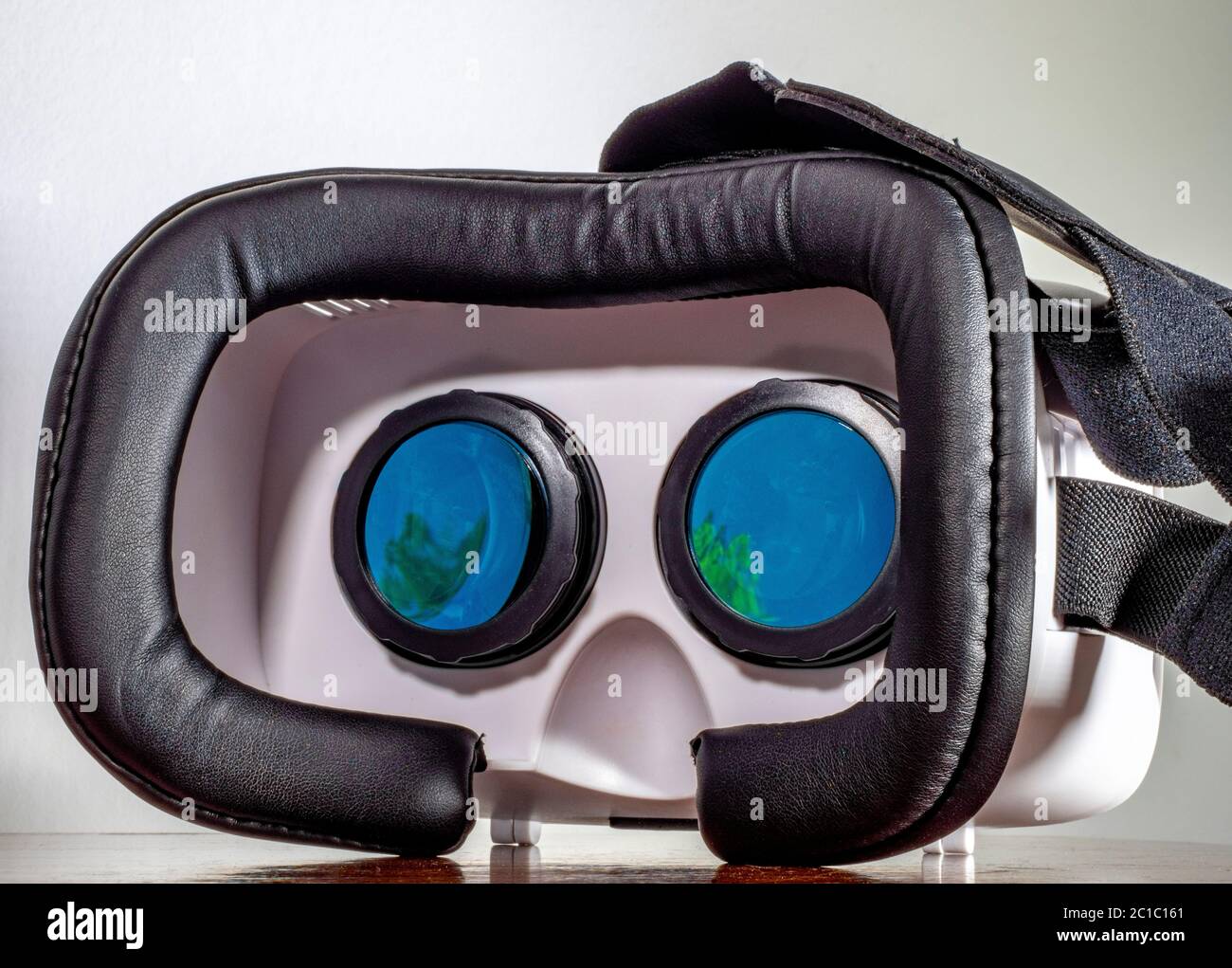 Casque / visière de réalité virtuelle VR et sangle élastique / serre-tête,  posé sur une surface, avec une application vidéo 3d EXPERIENCE jouant dans  les objectifs Photo Stock - Alamy
