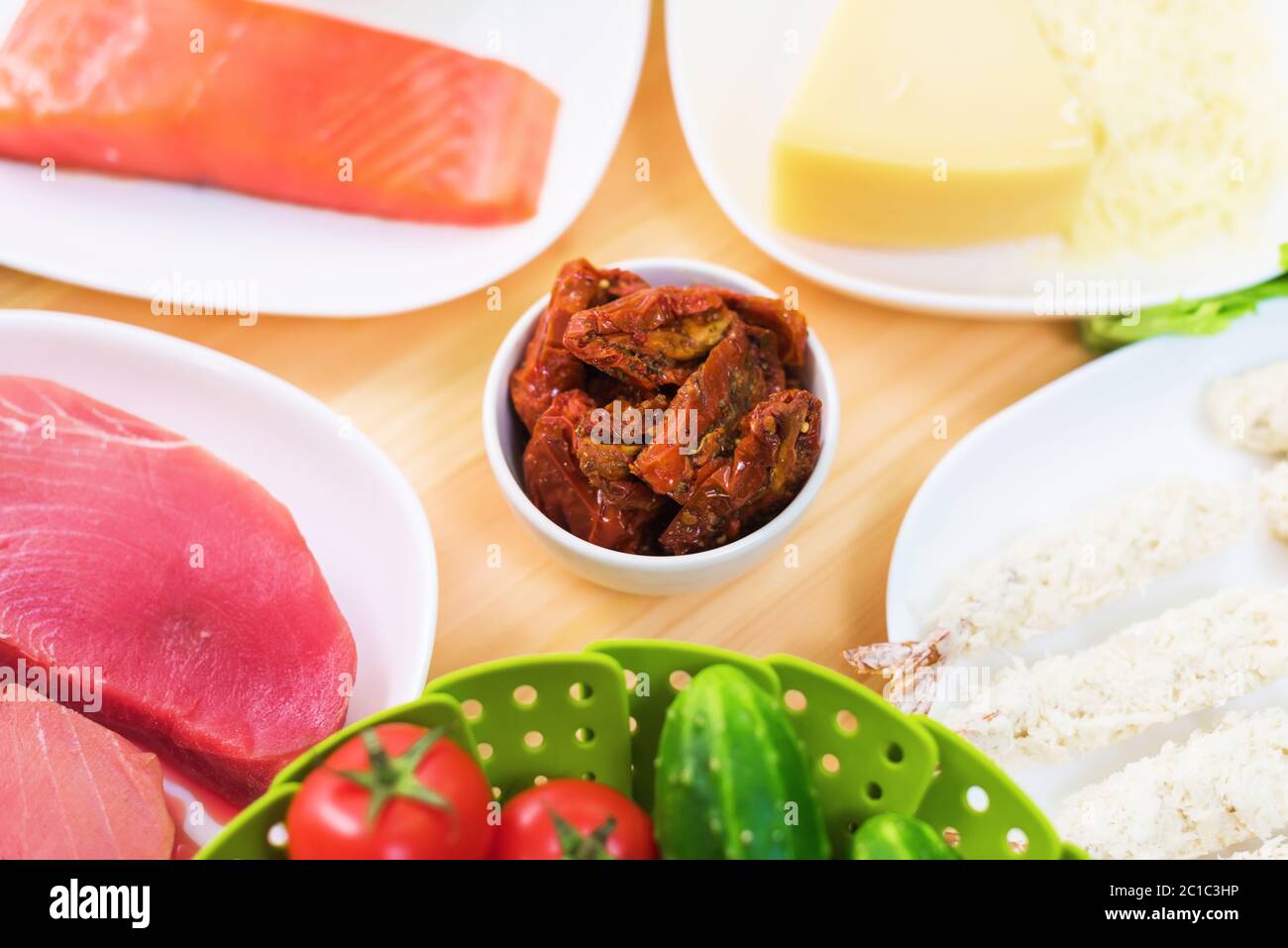 Filet de thon cru sur une table avec une cour de salade grecque avec des concombres et des tomates de saumon et de citron ainsi que du chee Banque D'Images