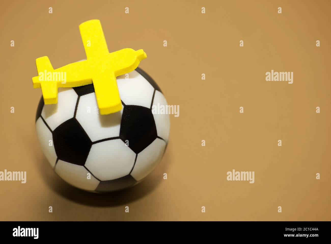 Avion jouet jaune sur un ballon de soccer. Le concept de l'avion pour le championnat de football. Banque D'Images