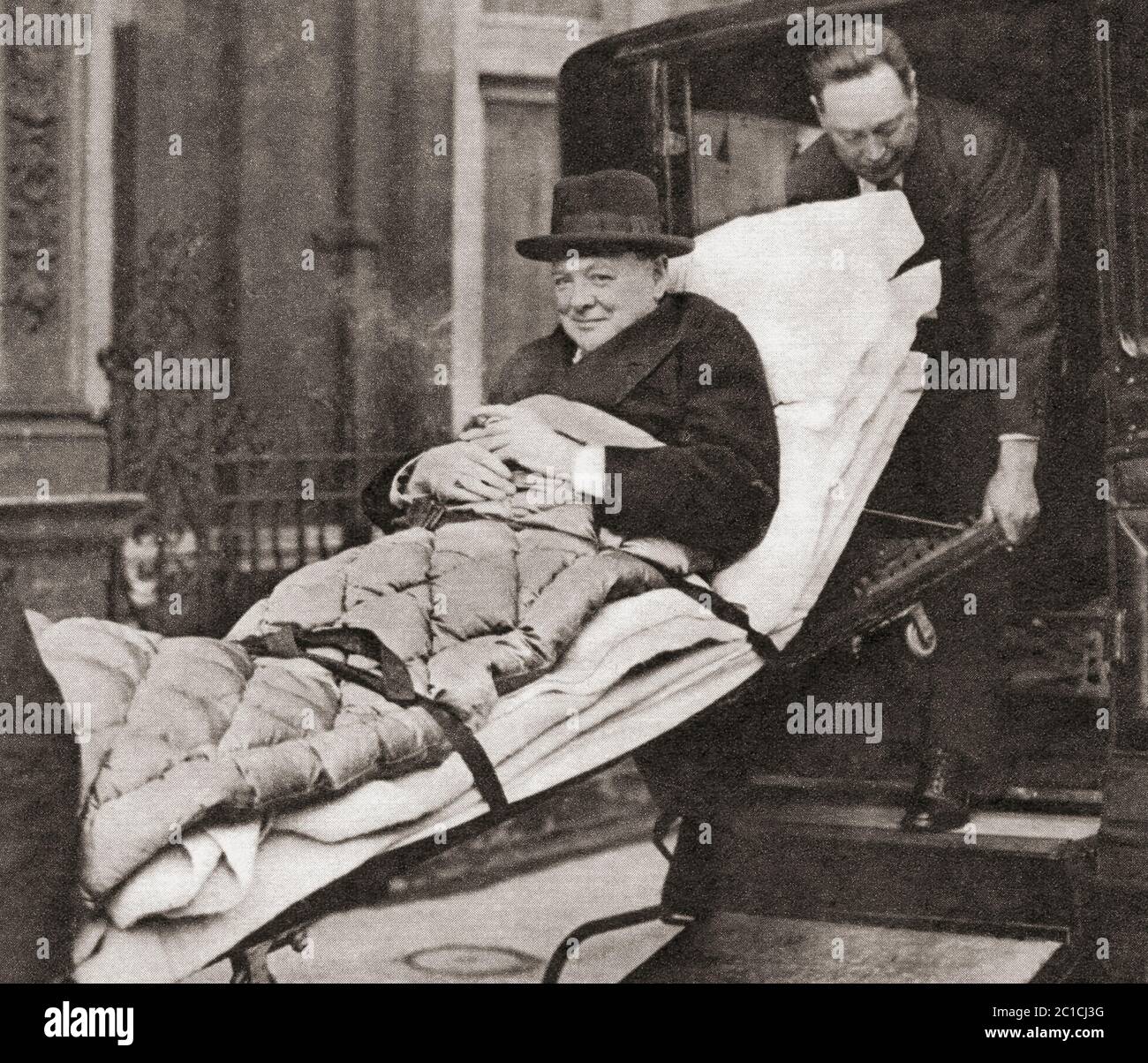 Sir Winston Churchill, vu ici en 1932, emmené à son appartement de Londres après avoir subi une attaque de paratyphoïde. Sir Winston Leonard Spencer-Churchill, 1874 – 1965. Politicien britannique, officier de l'armée, écrivain et deux fois Premier ministre du Royaume-Uni. Banque D'Images