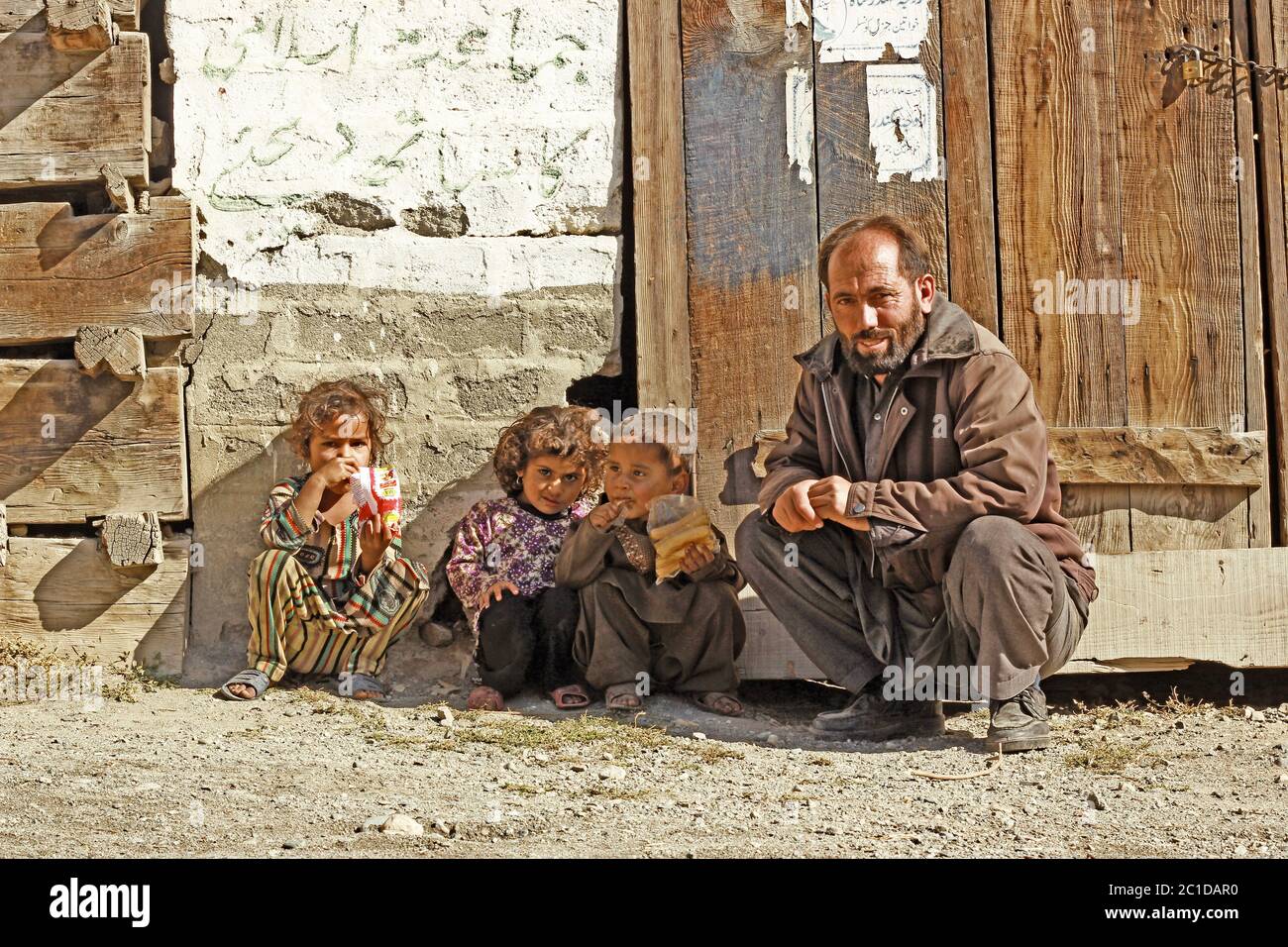 Homme assis avec ses enfants et souriant dans le district de Swat, khyber pakhtunkhwa, Pakistan 14/10/2015 Banque D'Images