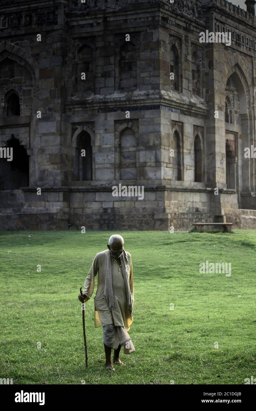 Un vieil homme marchant avec un bâton dans un jardin Lodhi à New Delhi Banque D'Images