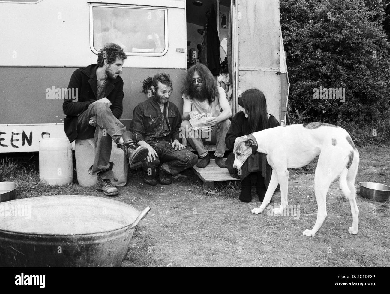Un groupe de voyageurs bavarde à l'extérieur de leur caravane sur un site près de Stonehenge au début des années 1990. ROYAUME-UNI. Banque D'Images
