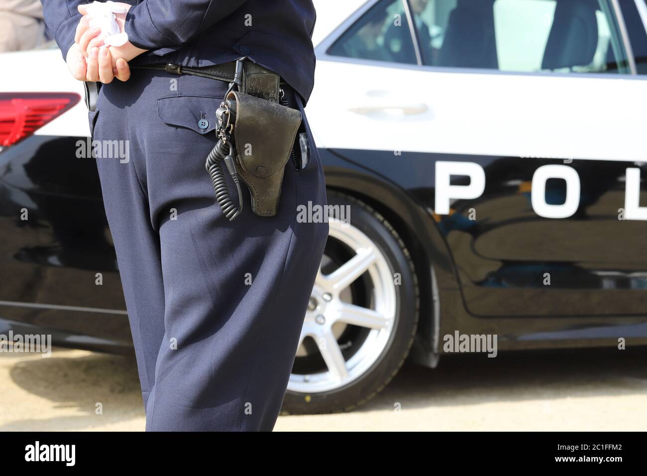 Vue arrière de l'agent de police japonais avec voiture de patrouille Banque D'Images