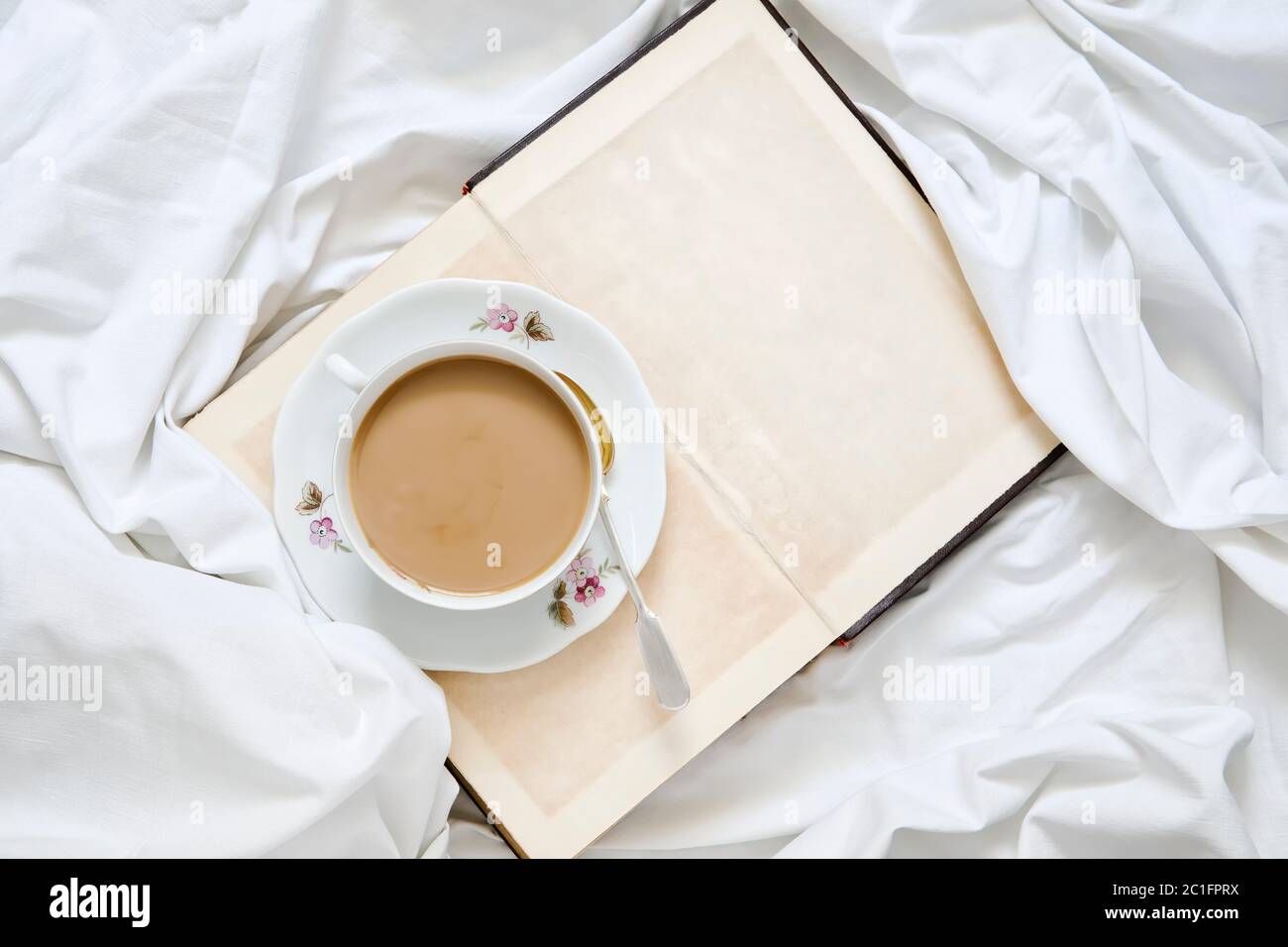 Tasse de cappuccino sur un livre et une feuille blanche Banque D'Images