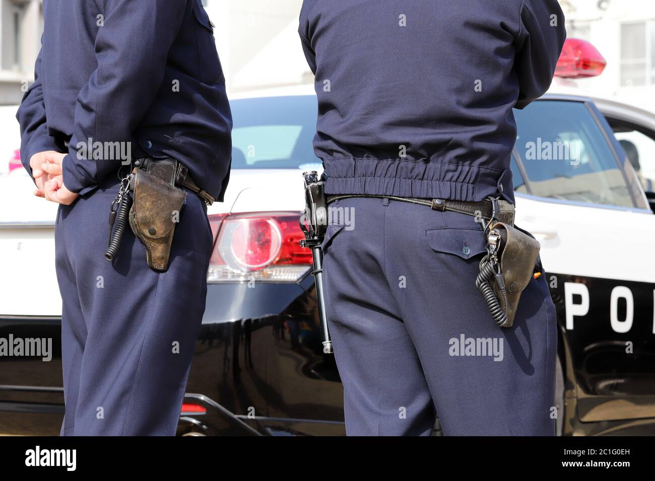 Vue arrière de l'agent de police japonais avec voiture de patrouille Banque D'Images