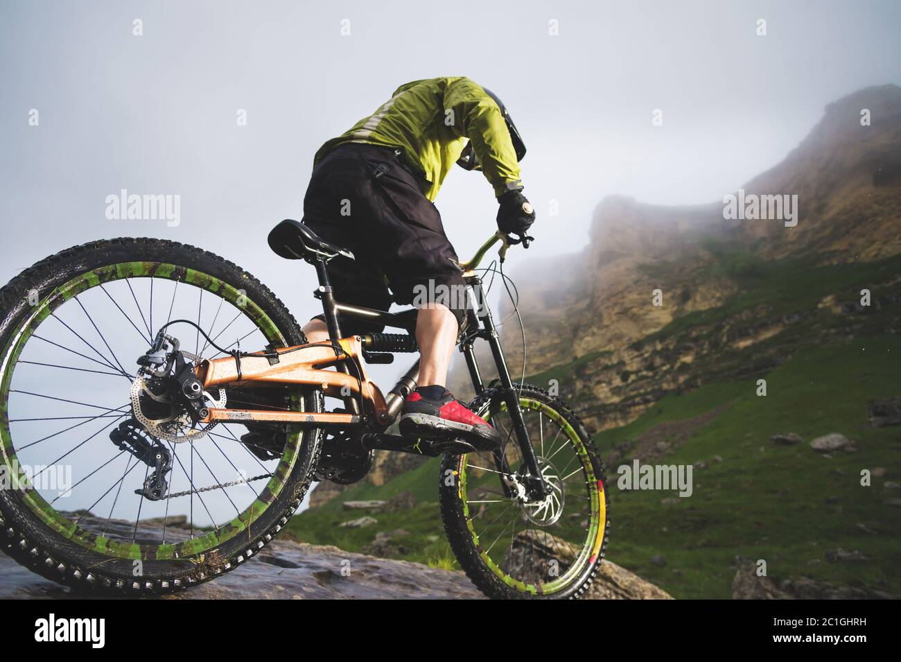 Sport extrême VTT sportif homme dans casque de conduite à l'extérieur sur un fond de rochers. Style de vie. Essai Banque D'Images