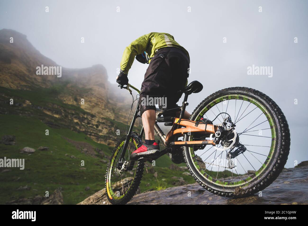 Sport extrême VTT sportif homme dans casque de conduite à l'extérieur sur un fond de rochers. Style de vie. Essai Banque D'Images