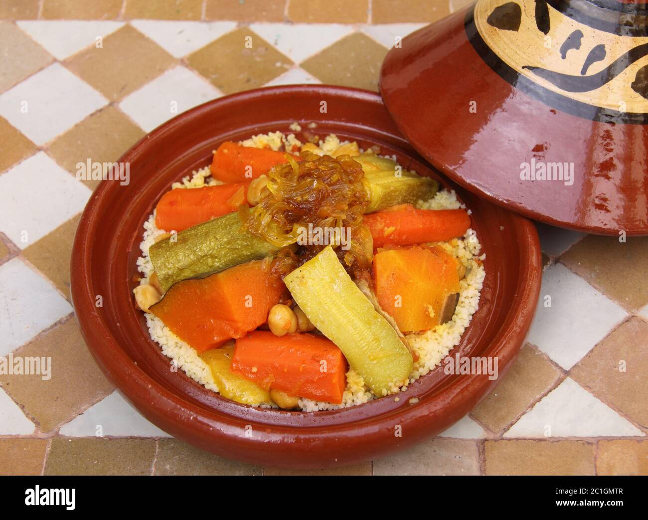Cuisine marocaine. Tajine typiquement tachée avec couscous, légumes et poulet. Banque D'Images