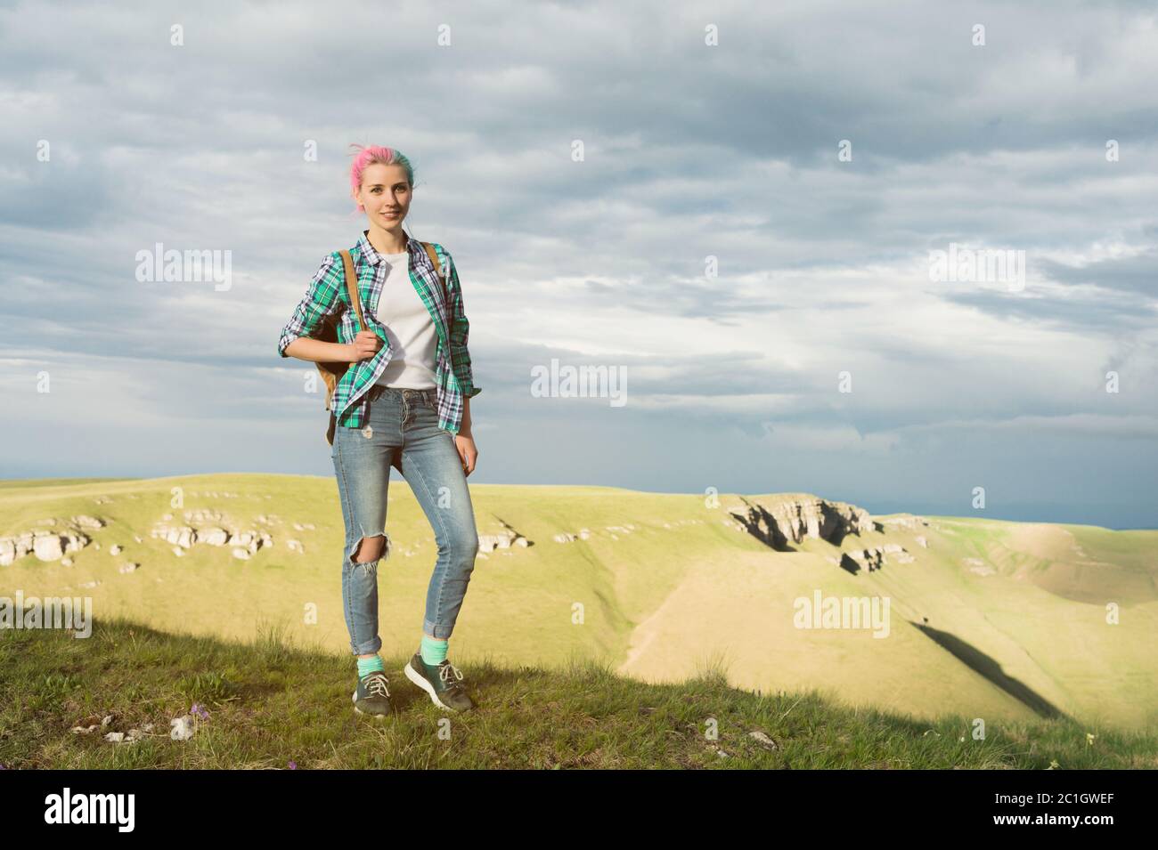 Une étudiante en plein air dans la campagne lors d'un voyage d'été souriant. Une femme de race blanche étudiant à l'université ou à l'université Banque D'Images