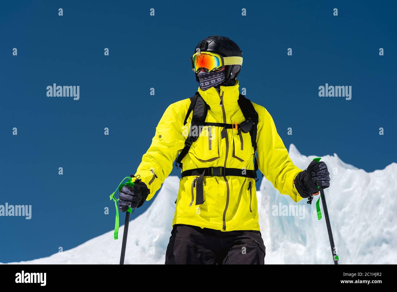 Skieur debout sur une pente. Homme en costume léger, le casque et le masque en ski est de skier. En arrière-plan, les montagnes enneigées Banque D'Images