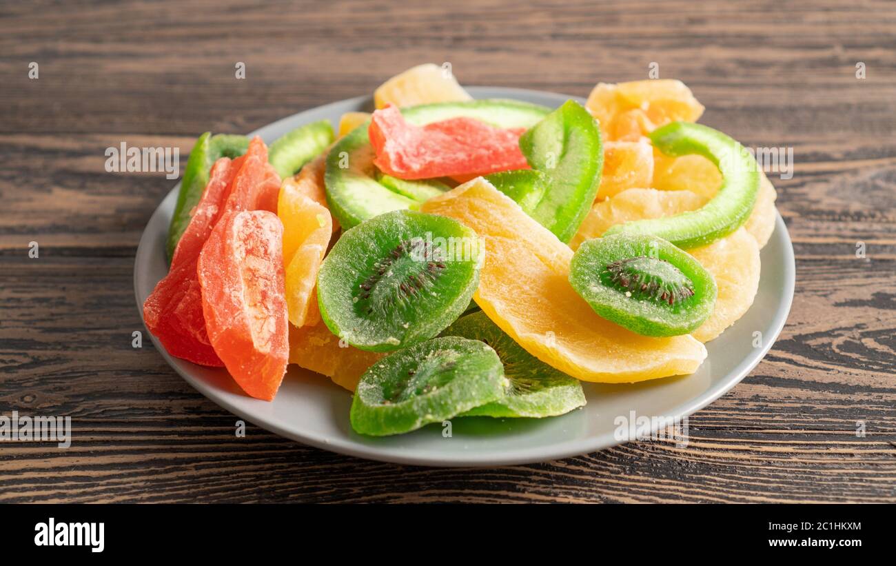 Menu de mets sains et sucrés pour enfants. Fruits séchés sur une assiette gros plan. Dessert diététique sur une table en bois Banque D'Images