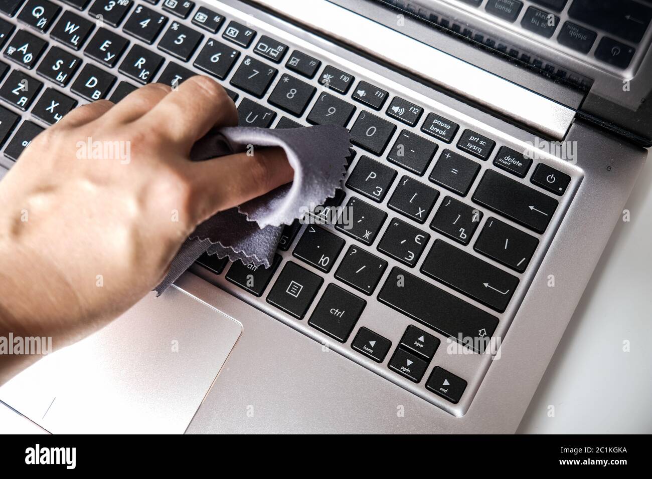 Nettoyage du clavier de l'ordinateur portable avec une serviette. Gros plan sur un ordinateur. Éliminer la poussière et tuer les bactéries pour rester en sécurité à la maison. Protection personnelle Banque D'Images