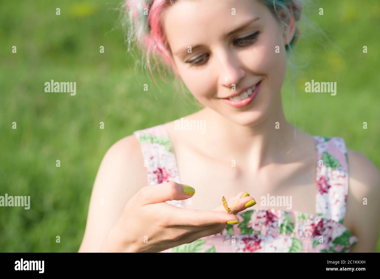 Portrait d'une belle femme tenant un papillon sur sa main dans le jardin. Portrait de beauté. Unité avec la nature. Concept d'écologie Banque D'Images